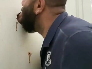 Bear sucks cock at a glory hole and gets the load