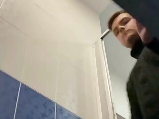 Young guy pissing in toilet stall